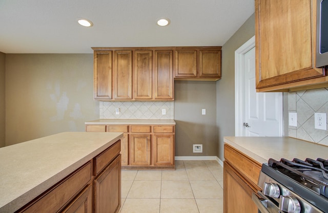 17919 Royal Gate Ln, Richmond, TX 77407 - kitchen with brown cabinets, decorative backsplash, light tile patterned flooring, light countertops, and recessed lighting