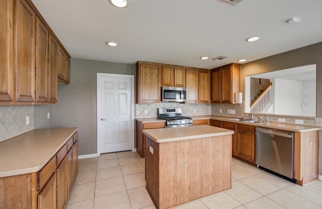 17919 Royal Gate Ln, Richmond, TX 77407 - kitchen featuring stainless steel appliances, a sink, backsplash, brown cabinetry, and recessed lighting