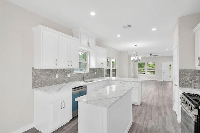 8022 Yoe St, Houston, TX 77078 - kitchen featuring stainless steel appliances, a peninsula, a sink, backsplash, and light wood-type flooring