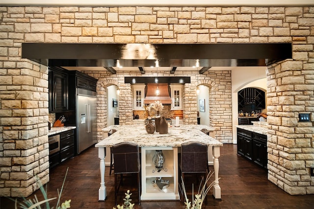 9 Copper Bottom Dr, Tomball, TX 77377 - kitchen featuring stainless steel built in fridge, custom exhaust hood, dark wood-type flooring, and a breakfast bar