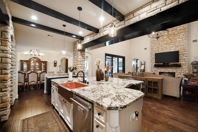 9 Copper Bottom Dr, Tomball, TX 77377 - kitchen featuring open floor plan, arched walkways, beamed ceiling, an island with sink, and a sink