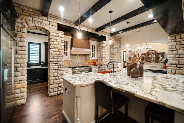 9 Copper Bottom Dr, Tomball, TX 77377 - kitchen with range with two ovens, beamed ceiling, light stone counters, dark wood finished floors, and a kitchen breakfast bar