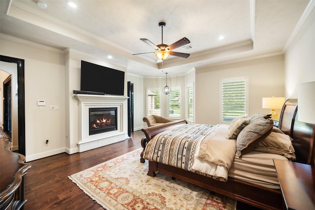 9 Copper Bottom Dr, Tomball, TX 77377 - bedroom with a tray ceiling, dark wood-style floors, a glass covered fireplace, ornamental molding, and baseboards
