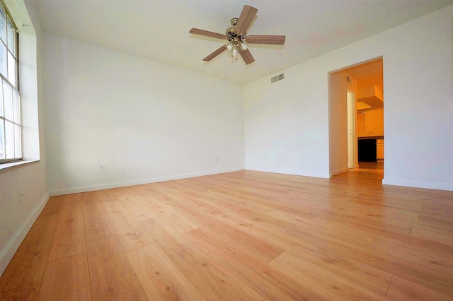 12048 Beechnut St, Houston, TX 77072 - empty room featuring light wood-type flooring, a ceiling fan, and baseboards
