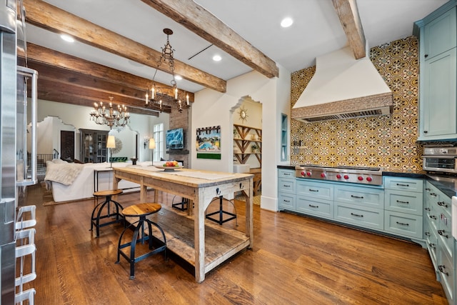 1915 Kirby Dr, Houston, TX 77019 - kitchen featuring stainless steel gas cooktop, premium range hood, a chandelier, green cabinetry, and backsplash