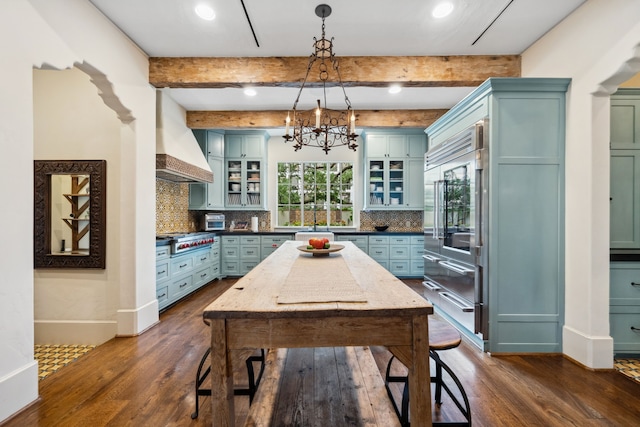 1915 Kirby Dr, Houston, TX 77019 - kitchen featuring stainless steel appliances, custom exhaust hood, dark wood-type flooring, decorative backsplash, and beam ceiling
