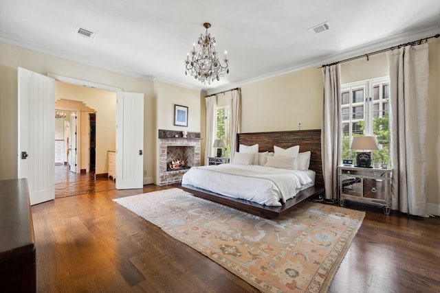 1915 Kirby Dr, Houston, TX 77019 - bedroom with a chandelier, dark wood-style flooring, ornamental molding, a brick fireplace, and baseboards