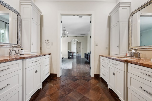1915 Kirby Dr, Houston, TX 77019 - bathroom featuring two vanities, ornamental molding, and baseboards