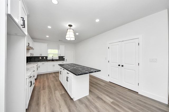 5046 Muske Ln, Brookshire, TX 77423 - kitchen with light wood-type flooring, backsplash, a kitchen island, white cabinets, and recessed lighting