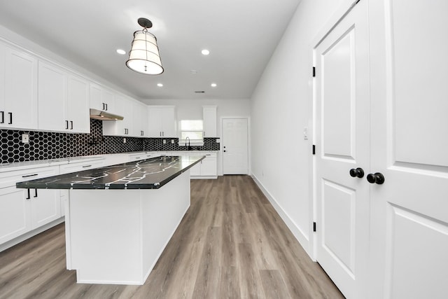 5046 Muske Ln, Brookshire, TX 77423 - kitchen with light wood-style floors, white cabinetry, decorative backsplash, a center island, and recessed lighting