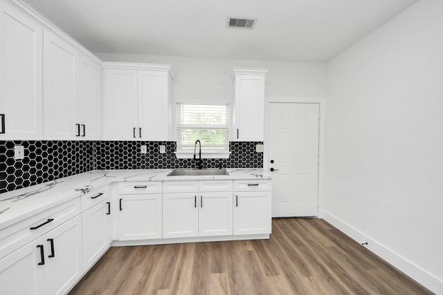 5046 Muske Ln, Brookshire, TX 77423 - kitchen with a sink, light wood-style floors, decorative backsplash, and white cabinets