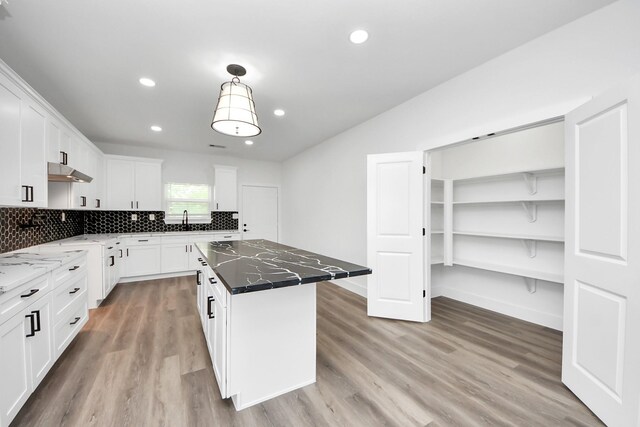 5046 Muske Ln, Brookshire, TX 77423 - kitchen with a kitchen island, light wood finished floors, decorative backsplash, white cabinetry, and recessed lighting