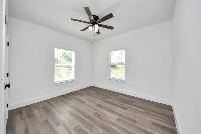 5046 Muske Ln, Brookshire, TX 77423 - spare room with plenty of natural light, baseboards, wood finished floors, and a ceiling fan