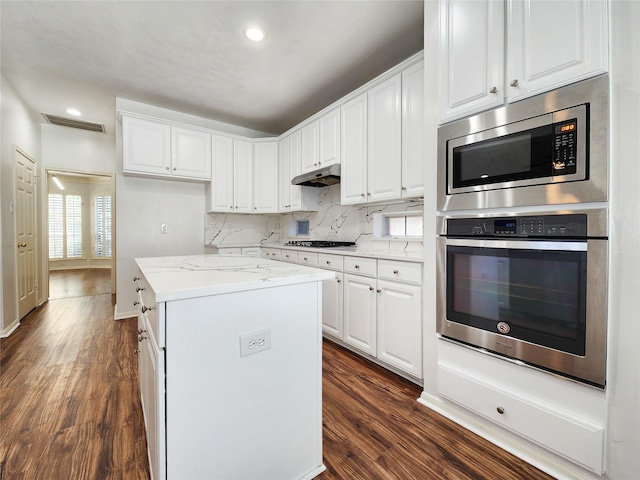 2927 Cambry Crossing Ct, Katy, TX 77494 - kitchen featuring stainless steel appliances, dark wood-type flooring, a center island, white cabinetry, and recessed lighting