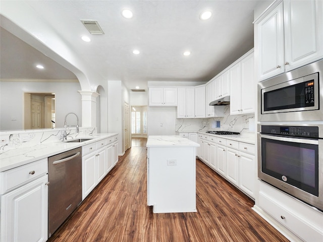 2927 Cambry Crossing Ct, Katy, TX 77494 - kitchen with appliances with stainless steel finishes, a sink, under cabinet range hood, white cabinetry, and recessed lighting