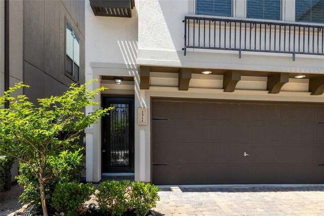 1511 Peyton Oaks Pl, Houston, TX 77043 - entrance to property featuring an attached garage, a balcony, and stucco siding