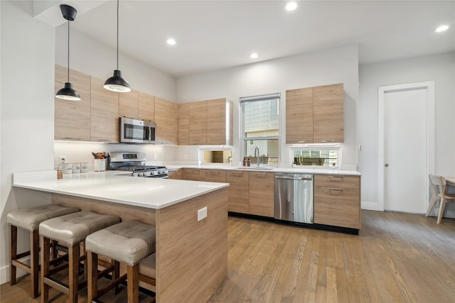 2809 St Emanuel St, Houston, TX 77004 - kitchen featuring stainless steel appliances, a sink, modern cabinets, a breakfast bar, and recessed lighting