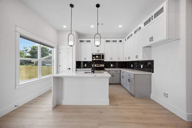 4825 Pederson St A/B, Unit A/B Houston, TX 77033 - kitchen featuring stainless steel appliances, baseboards, tasteful backsplash, light countertops, and a center island with sink
