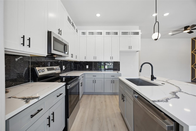 4825 Pederson St A/B, Unit A/B Houston, TX 77033 - kitchen with stainless steel appliances, a sink, light wood-type flooring, backsplash, and light stone countertops