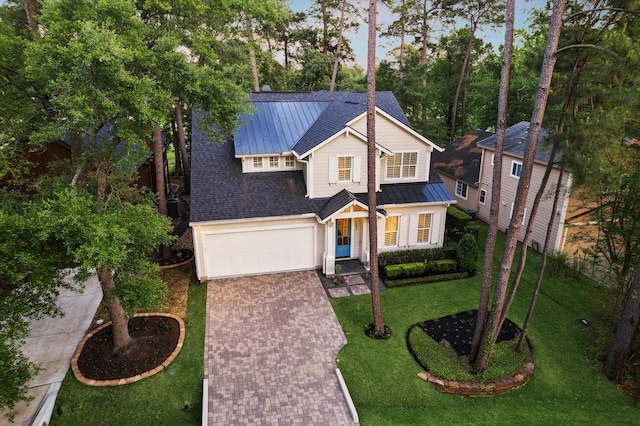 183 Timber Mill St, The Woodlands, TX 77380 - traditional home featuring decorative driveway, an attached garage, metal roof, a standing seam roof, and a front yard