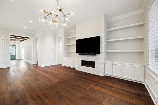 183 Timber Mill St, The Woodlands, TX 77380 - unfurnished living room featuring a chandelier, a fireplace, crown molding, built in features, and dark wood-type flooring