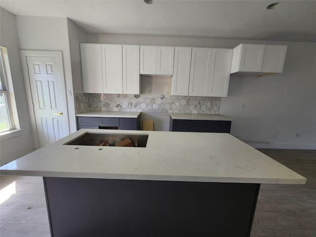 8208/8210 Knox St, Houston, TX 77088 - kitchen featuring a kitchen island, decorative backsplash, white cabinetry, baseboards, and wood finished floors