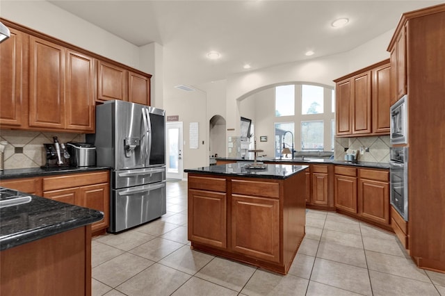 22734 Newcourt Place St, Tomball, TX 77375 - kitchen with stainless steel appliances, a sink, arched walkways, tasteful backsplash, and a center island