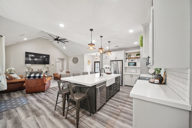 7332 Kurt Dr, Brenham, TX 77833 - kitchen with a sink, open floor plan, stainless steel appliances, a breakfast bar area, and recessed lighting