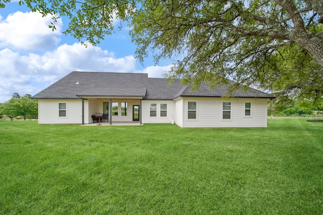 7332 Kurt Dr, Brenham, TX 77833 - back of house featuring a patio area, a yard, roof with shingles, and a trampoline