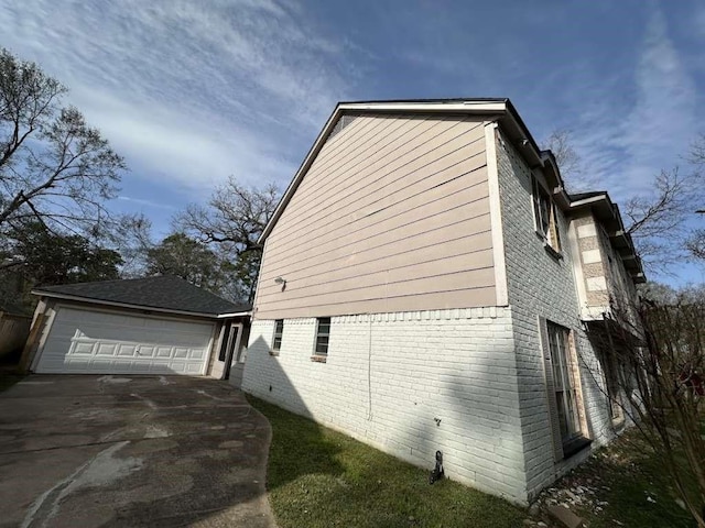 706 Redleaf Ln, Houston, TX 77090 - view of home's exterior with brick siding, a detached garage, and an outdoor structure