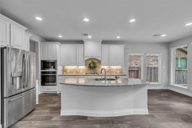 126 Capriccio Ln, Montgomery, TX 77316 - kitchen with stainless steel appliances, a sink, tasteful backsplash, white cabinetry, and recessed lighting