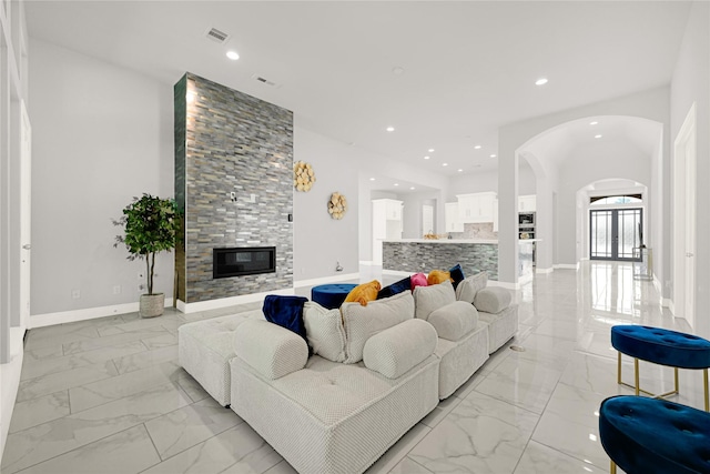 19236 Yellow Chestnut Ln, New Caney, TX 77357 - living area with light marble finish floors, arched walkways, a fireplace, recessed lighting, and baseboards