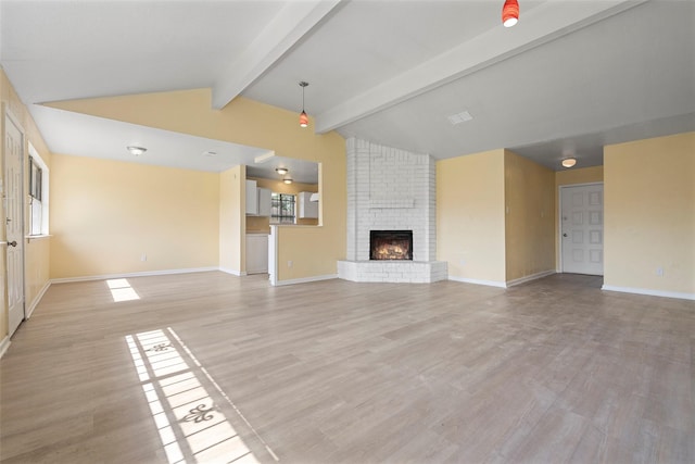 14118 Magnolia Springs Dr, Houston, TX 77066 - unfurnished living room featuring light wood-type flooring, baseboards, a brick fireplace, and plenty of natural light