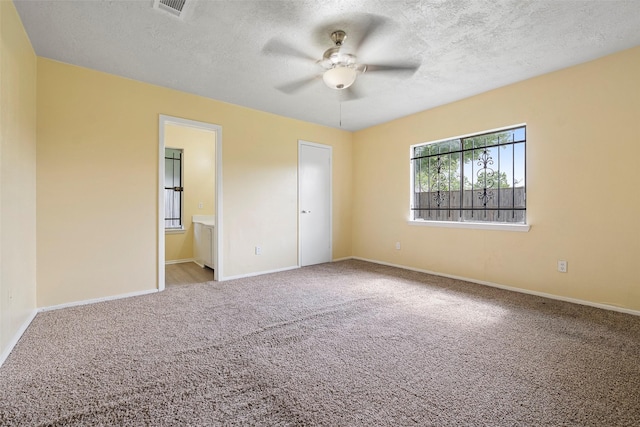 14118 Magnolia Springs Dr, Houston, TX 77066 - unfurnished bedroom with carpet floors, baseboards, a textured ceiling, ensuite bathroom, and a ceiling fan