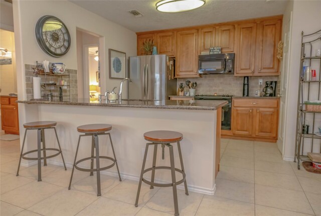 22113 Matagorda Dr, Galveston, TX 77554 - kitchen with appliances with stainless steel finishes, backsplash, and a kitchen breakfast bar