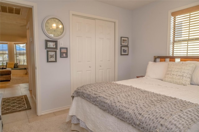 22113 Matagorda Dr, Galveston, TX 77554 - bedroom with tile patterned flooring, a closet, multiple windows, and baseboards