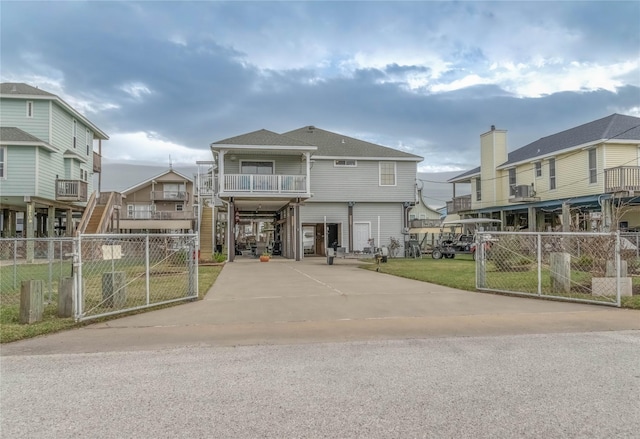 22113 Matagorda Dr, Galveston, TX 77554 - view of front facade featuring concrete driveway, a gate, and a carport