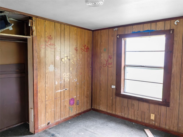 3200 Moore Ave, Bay City, TX 77414 - unfurnished bedroom with multiple windows, carpet flooring, wood walls, and baseboards