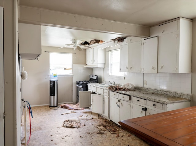 3200 Moore Ave, Bay City, TX 77414 - kitchen featuring stainless steel gas stove, tasteful backsplash, a ceiling fan, white cabinetry, and a sink