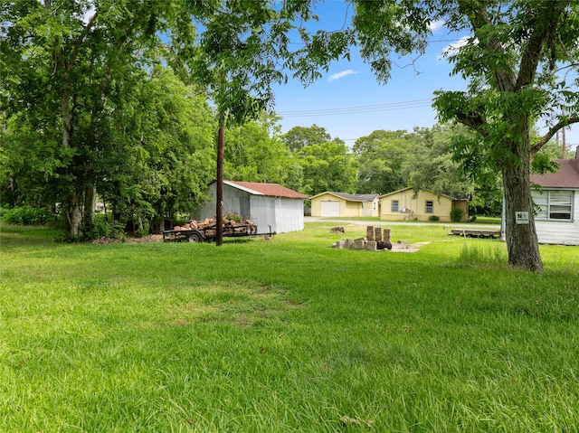 3200 Moore Ave, Bay City, TX 77414 - view of grassy yard with a garage, an outdoor fire pit, and an outbuilding