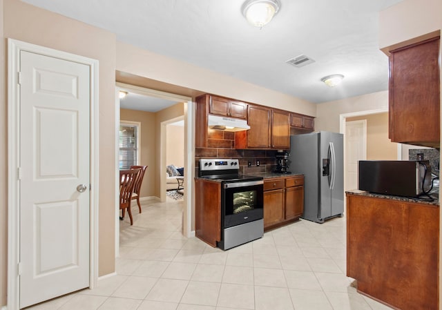 8726 Tilgham St, Houston, TX 77029 - kitchen featuring appliances with stainless steel finishes, under cabinet range hood, decorative backsplash, brown cabinets, and light tile patterned flooring
