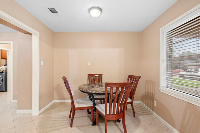 8726 Tilgham St, Houston, TX 77029 - dining area featuring washer / clothes dryer, baseboards, and light tile patterned floors