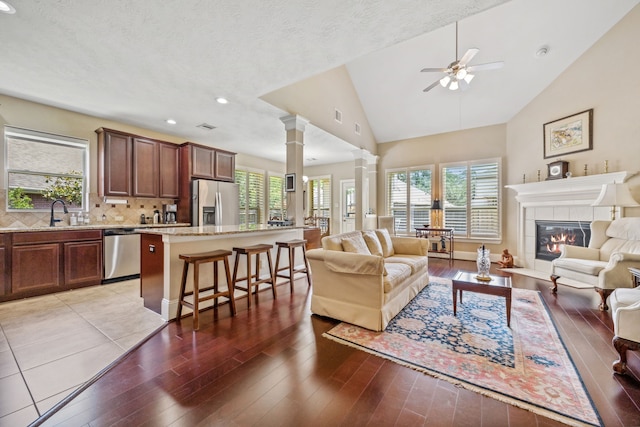 14418 Brushy Arbor Ln, Humble, TX 77396 - living room featuring ornate columns, light wood-style floors, a ceiling fan, a fireplace, and recessed lighting