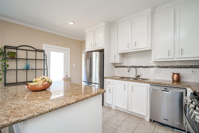 2116 Carter St, Houston, TX 77008 - kitchen with appliances with stainless steel finishes, a sink, decorative backsplash, white cabinetry, and crown molding