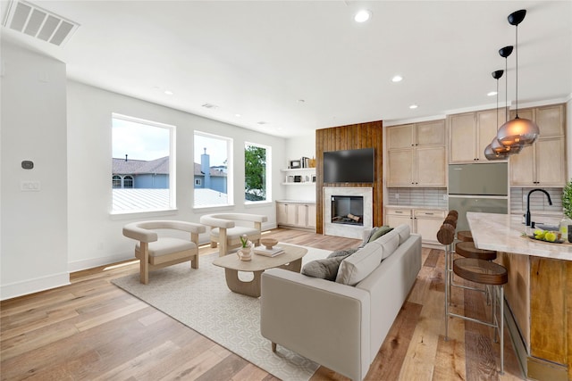 5439 Darling St, Houston, TX 77007 - living area featuring light wood-type flooring, a fireplace, recessed lighting, and baseboards