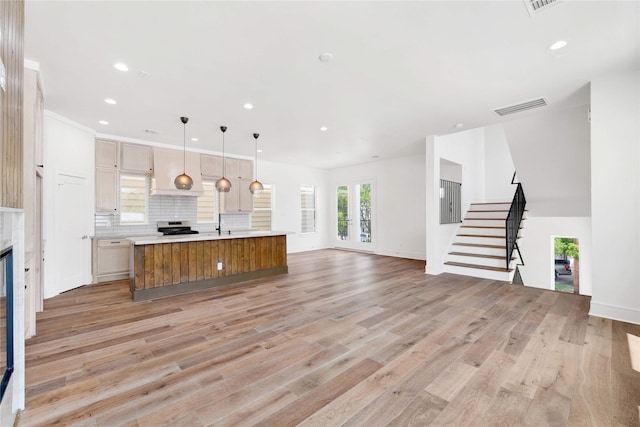 5439 Darling St, Houston, TX 77007 - unfurnished living room with stairway, light wood-type flooring, recessed lighting, and a glass covered fireplace