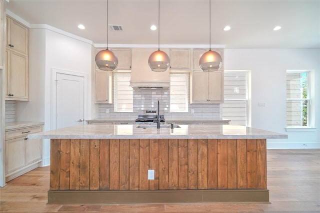 5439 Darling St, Houston, TX 77007 - kitchen with a sink, decorative backsplash, a kitchen island with sink, light stone countertops, and light wood-type flooring