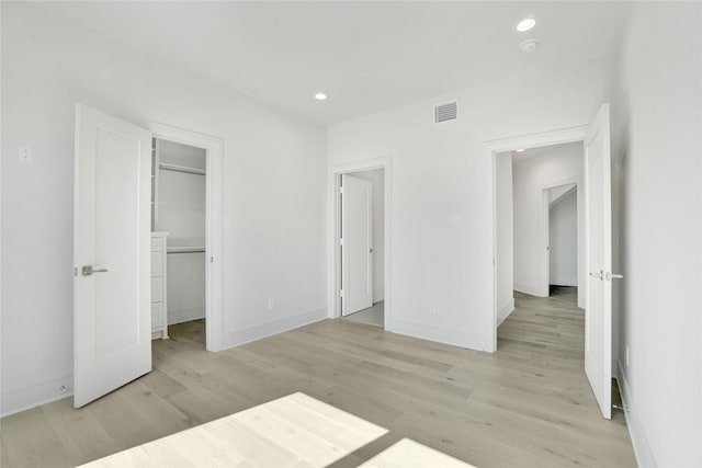5439 Darling St, Houston, TX 77007 - unfurnished bedroom with light wood finished floors, a spacious closet, recessed lighting, and baseboards