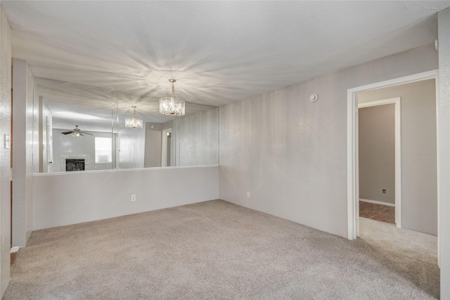9700 Leawood Blvd Unit 7/16, Houston, TX 77099 - spare room featuring carpet flooring, a chandelier, a fireplace, and a ceiling fan