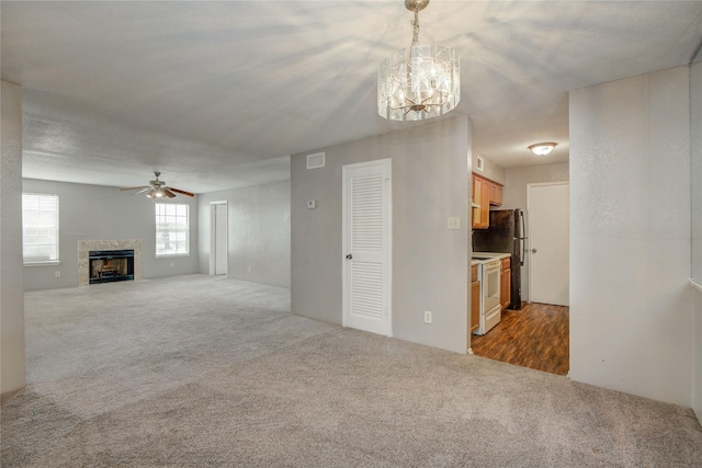 9700 Leawood Blvd Unit 7/16, Houston, TX 77099 - unfurnished living room with carpet floors, a premium fireplace, a ceiling fan, and a chandelier